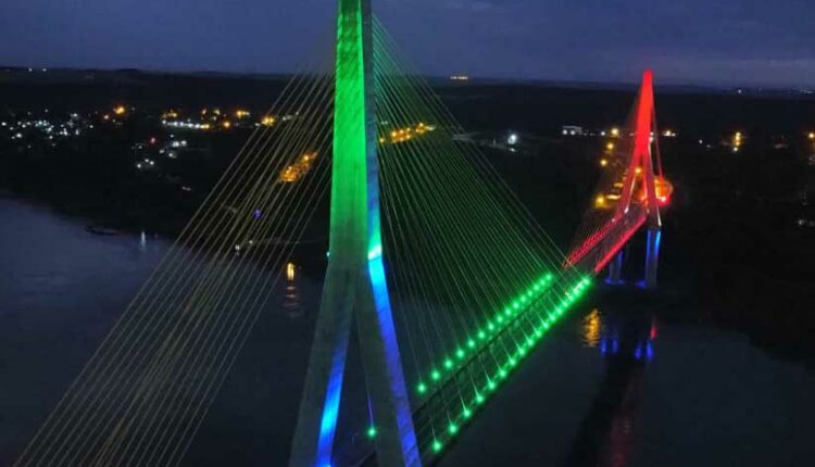 Imagem publicada no Facebook da Prefeitura de Foz mostra a ponte iluminada meio a meio. Foto: Gentileza/DER-PR
