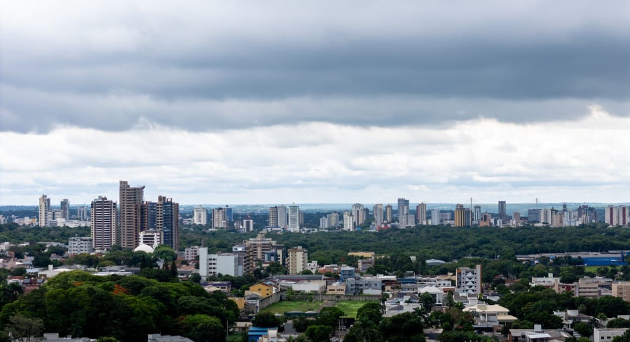 Atrás dos prédios da área central de Foz do Iguaçu, é possível ver os pilares da Ponte da Integração.