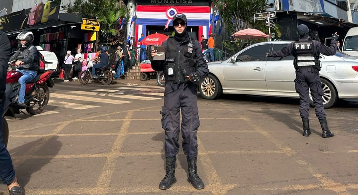Policial exibe a carteira encontrada em área de grande fluxo comercial no Paraguai.