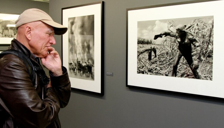 Sebastião Salgado contempla uma de suas obras durante a exposição de 2014 no Ecomuseu.