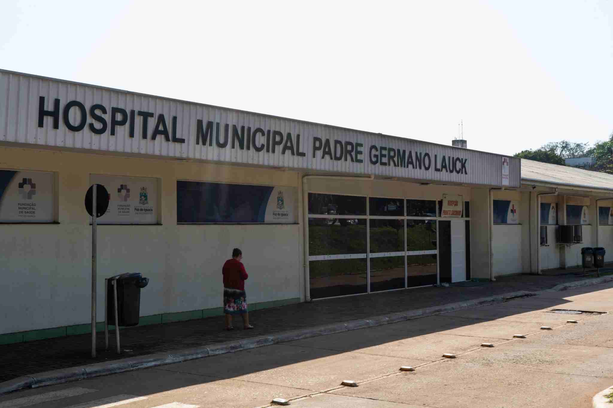 Mulher em frente à fachada lateral do Hospital Municipal Padre Germano Lauck