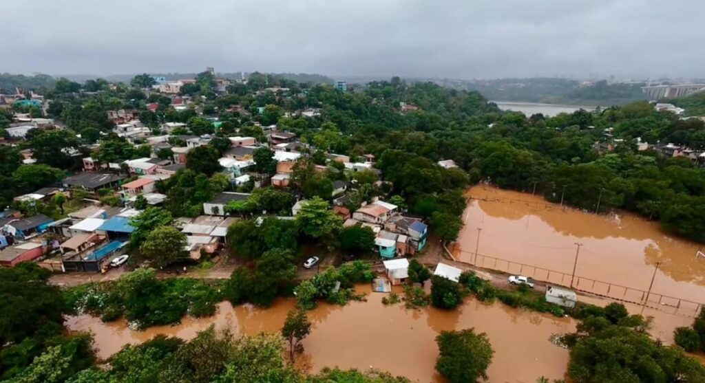 Efeitos da enchente no bairro San Rafael, em Ciudad del Este; ao fundo, a Ponte Internacional da Amizade, na fronteira com Foz do Iguaçu.