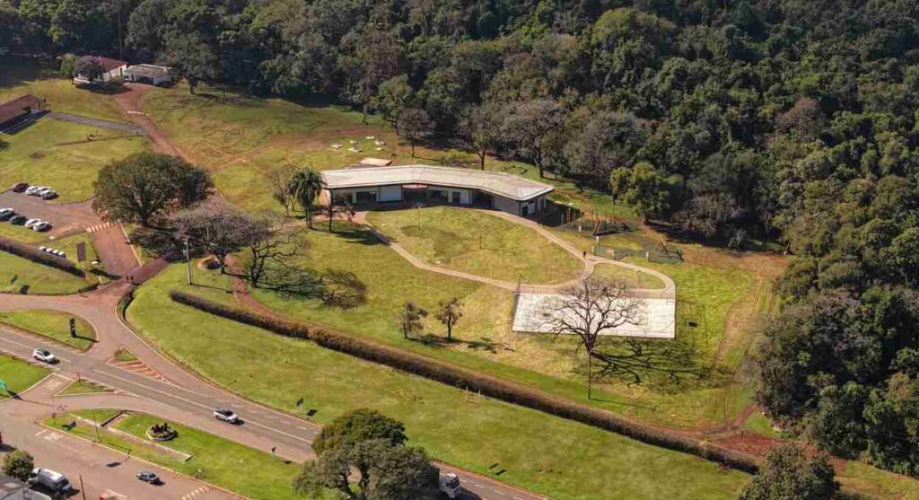 Vista aérea do Polo Rio Azul: o novo Centro de Visitantes, a quadra poliesportiva e o playground ficam ao lado da mata do Parque Nacional do Iguaçu. Foto: Urbia+Cataratas e Eagle Eye Company